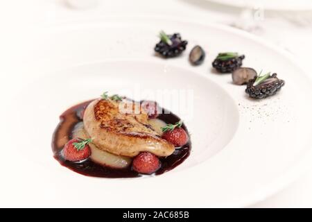 Foie gras poêlé aux fruits rouges et sauce au porto dans porcalain, tonique de la plaque libre Banque D'Images