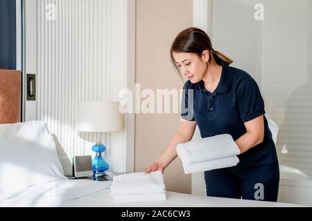 Nettoyer la chambre de ménage et remplacer le draps et serviettes. Banque D'Images