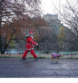 Edinburgh, Ecosse, Royaume-Uni. 1er décembre 2019. La collecte d'Édimbourg en course et marche Santa West Princes Street Gardens, de recueillir des fonds pour les enfants malades pour quand vous voulez sur une étoile de la charité. Santa de promener le chien en dessous du château d'Édimbourg. Credit : Craig Brown/Alamy Live News Banque D'Images