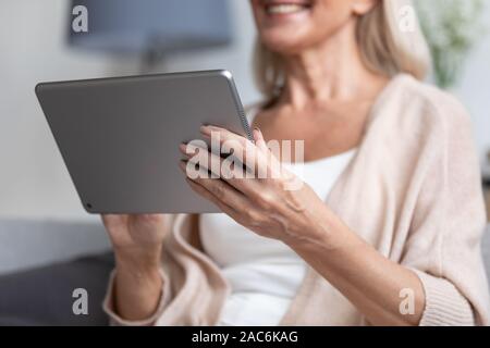 Gros plan femme selective focus on arms holding tablet device Banque D'Images