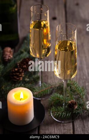 Deux verres de champagne avec bougie allumée sur une table en bois rustique Banque D'Images