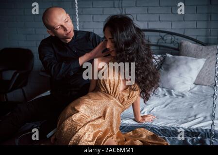 Toucher doux. Couple dans l'usure classique se trouve en face de la magnifique lit décoré de luxe Banque D'Images