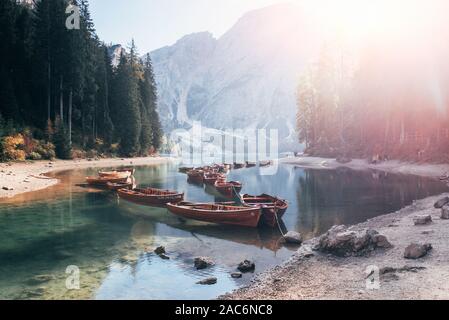 Connecté sur les bateaux est l'eau claire à proximité de la forêt et de belles montagnes majestueuses Banque D'Images