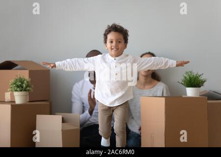 Happy cute hispanic petit enfant garçon jouant près de boîtes. Banque D'Images