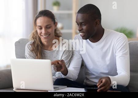 Happy mixed race family conjoint effectuant des calculs budgétaires. Banque D'Images