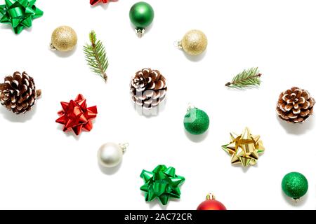 Composition diagonale avec Noël rouge, vert et boules d'or, les arcs, les branches de sapin et des pommes de pin isolated on white Banque D'Images
