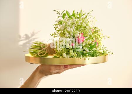 Bouquet de fleurs de printemps frais de rose rose, le muguet, Viburnum branches sur Bac. en art floral, le travail de fleuriste, boutique de fleurs, beauté Banque D'Images