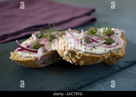 La photographie culinaire de grain entier grillé crostini avec fromage à la crème, câpres et d'aneth Banque D'Images