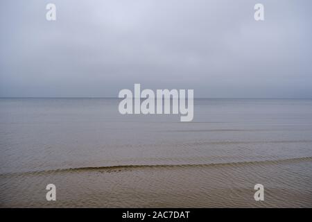 Plage de la mer congelés avec du sable et de la neige en premier jour nuageux en hiver Banque D'Images