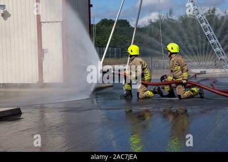 Les pompiers l'objet d'une session de formation à l'aide d'un tuyau d'eau à pression maximale dans le West Yorkshire, Angleterre, Royaume-Uni Banque D'Images