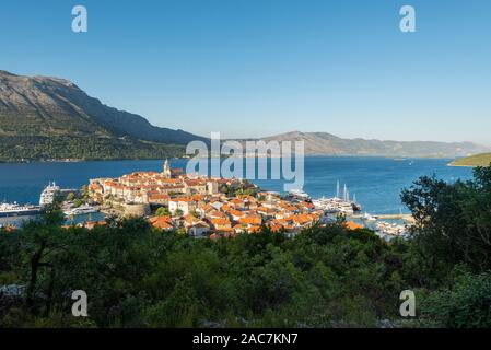 Panorama des rues médiévales et des bâtiments de la vieille ville historique de Korcula en face de l'île de Peljesac sous le soleil d'après-midi, la Croatie Banque D'Images