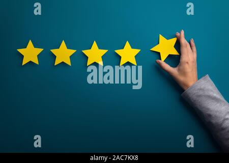 Main femme donner cinq étoiles sur vert Banque D'Images