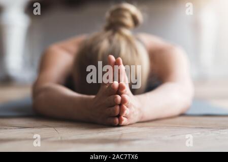 Woman face vers le bas sur un tapis de yoga, méditer Banque D'Images