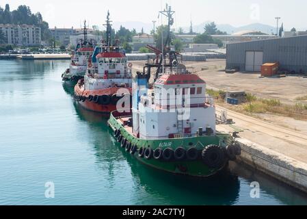 Trois remorqueurs colorés avec des pneus sur le côté du navire amarré dans le port de Ploče au soleil, Dalmatie, Croatie, Europe Banque D'Images