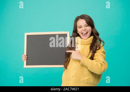 Petit enfant pointer du doigt quelque chose. Bienvenue à bord. meilleurs prix. info utile ici. bonne petite fille tenir tableau. grande publicité de vente. copie espace pour votre message publicitaire. Banque D'Images