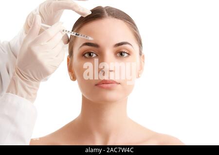 Portrait d'une jolie jeune femme qui reçoit un traitement de botox. Isolé sur fond blanc. Banque D'Images