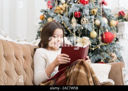 Club de la littérature. Esprit de Noël. Lecteur peu profiter de la lecture à la maison. Meilleur livre De Noël. Boutique Livres commerciaux. Peu de sourire enfant lire livre. Nouvel an. Petite fille lecture histoire de Noël. Banque D'Images