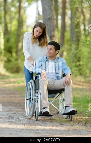 Couple avec fauteuil roulant en forêt d'automne Banque D'Images