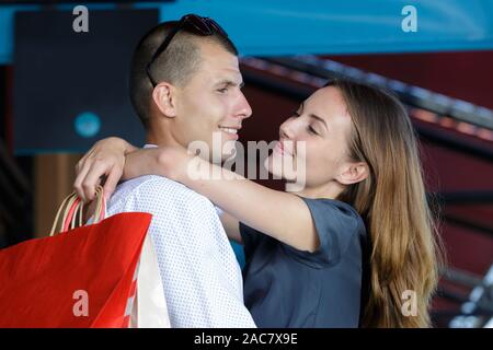 Young couple embracing in mall tandis que sur le shopping venture Banque D'Images