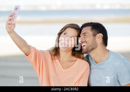 En couple avec un téléphone et selfies décisions silly faces Banque D'Images