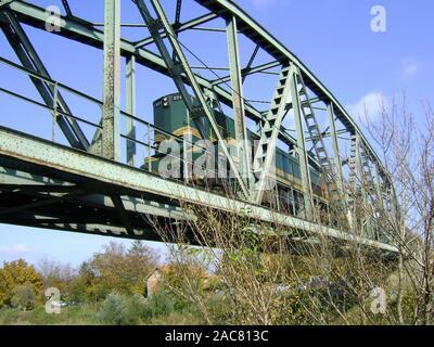 Zrenjanin, Serbie, 28 octobre 2009. Une locomotive tirant un train entre un pont sur la rivière. Banque D'Images