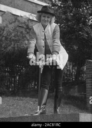 Années 1980, historiques, une dame avec un bâton de prise de certains des derniers modèles British countrywear, England, UK. Banque D'Images