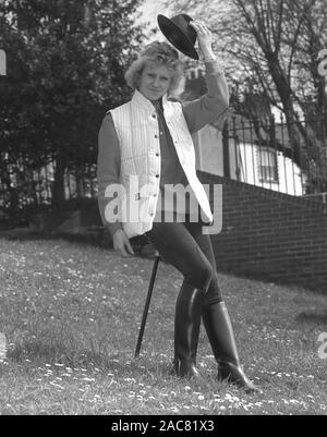 Années 1980, historiques, une dame avec un bâton de prise de certains des derniers modèles British countrywear, England, UK. Banque D'Images