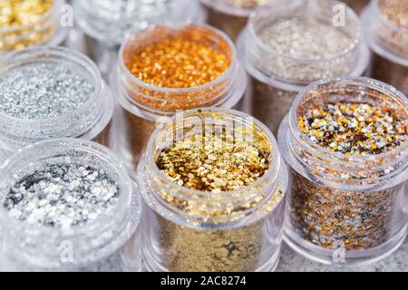 Belle glitter close up dans les tons d'or et d'argent dans de petits pots de verre, selective focus Banque D'Images