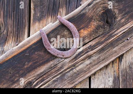 Old rusty horseshoe cloué à un mur de la grange en bois patiné Banque D'Images