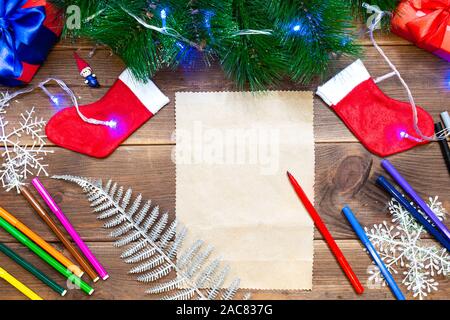 Les enfants lettre au Père Noël. Petite fille écrit une lettre avec des feutres de couleur sur une table en bois avec des décorations de Noël sur l'ancien Banque D'Images