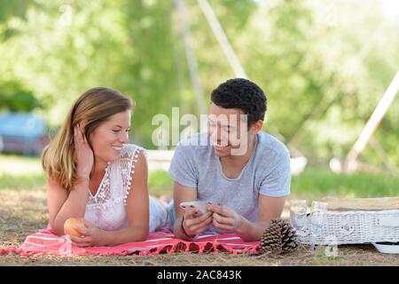 L'homme et la femme avec une tablette sur l'herbe Banque D'Images