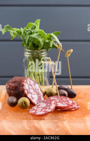 Apéritif de salami, vert et olives calamata et roquette servis sur hymalayan vertical bloc sel rose Banque D'Images