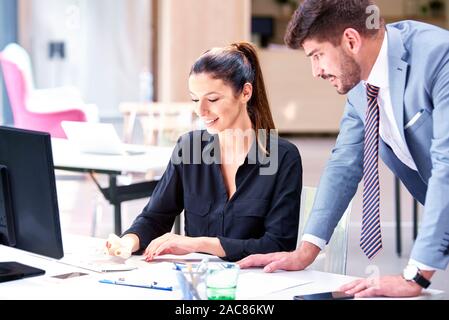 Groupe de gens d'affaires qui travaillent ensemble sur la réunion. Attractive businesswoman sitting at Office 24 et la tenue de document dans sa main tout en confiant Banque D'Images