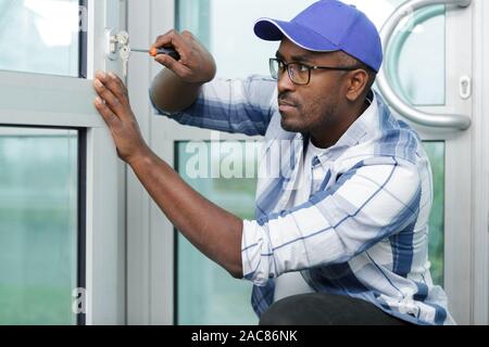 Raccords de travail de l'homme sur une fenêtre Banque D'Images