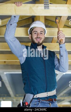 Homme builder sur le toit d'une maison à ossature en bois Banque D'Images