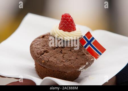 Un petit gâteau au chocolat avec pavillon norvégien sur une serviette blanche. L'ofr Célébration 17 mai. Banque D'Images