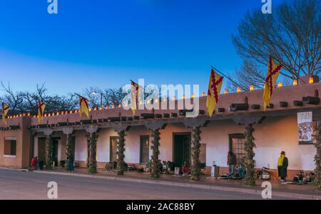 Noël Santa Fe, Palais des Gouverneurs sur la plaza avec farolitos au crépuscule, Santa Fe New Mexico, USA. Banque D'Images