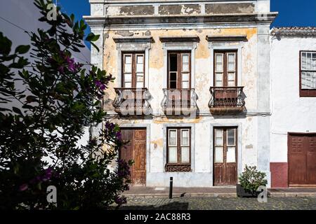 Vieux bâtiment blanc aux fenêtres et portes en bois patiné et fer à repasser balcon travail de peinture à Garachico, Tenerife, Espagne le 23 novembre 2019 Banque D'Images