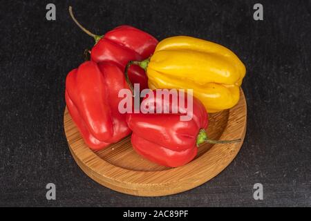 Groupe de quatre ensemble hot chili habanero sur bambou ronde en pierre grise sur les montagnes russes Banque D'Images