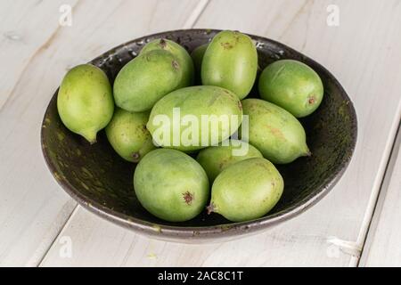 Beaucoup d'hardy dans kiwi vert bol émaillés sur bois blanc Banque D'Images