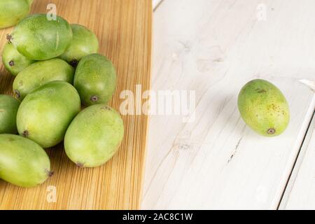 Beaucoup de vert kiwi sur toute hardy planche à découper en bambou sur bois blanc Banque D'Images