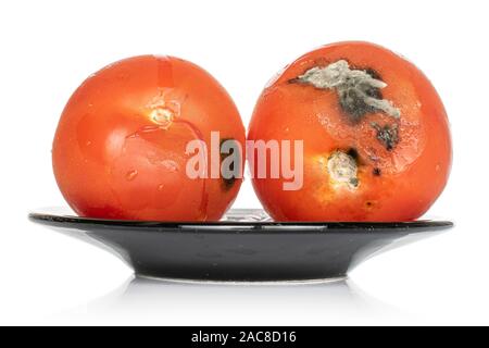 Groupe de deux ensemble tomate rouge rassis sur la plaque noire isolé sur fond blanc Banque D'Images