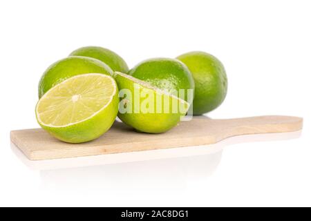 Groupe de quatre ensemble deux moitiés de sour lime vert sur planche à découper en bois isolé sur fond blanc Banque D'Images