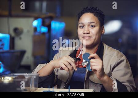 Portrait of African-American woman looking at camera tout en travaillant à la ligne de production à l'usine, copy space Banque D'Images