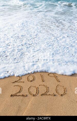 2019 2020 écrit dans le sable avec une vague d'effacer 2019- concept du Nouvel An Banque D'Images