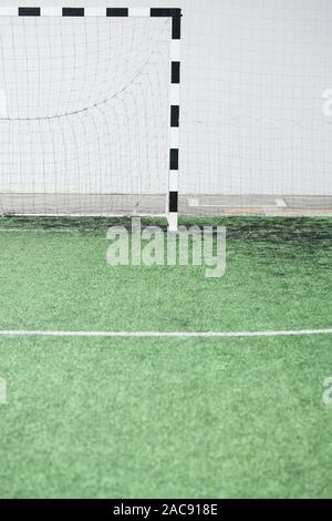 Une partie de terrain de football vide vert et gates avec net contre mur blanc au stade contemporain Banque D'Images