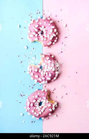 Mise en page créative faite de rose mordu des beignes. Concept alimentaire. Banque D'Images