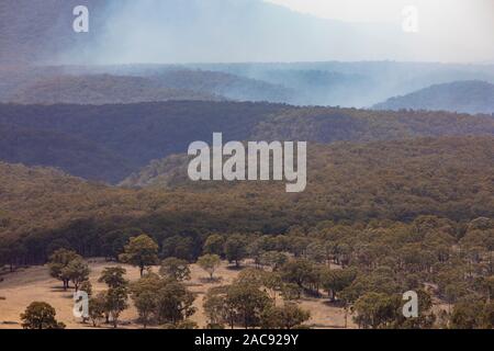 Capertee Valley près de Blue Mountains en été, la fumée avant de bush à travers la vallée, New South Wales, Australie Banque D'Images