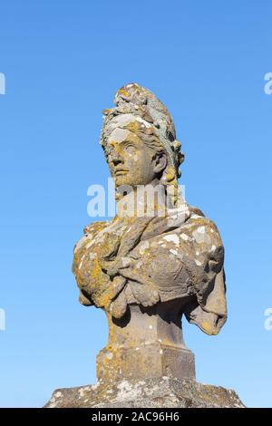 Old weathered stone buste de Marianne, symbole de la France et de la République française de la liberté et de la raison allégorique, couvert de lichens colorés contre Banque D'Images