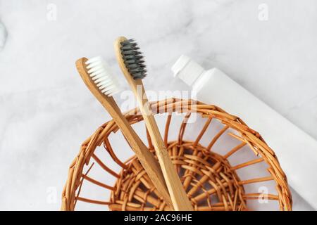 Ensemble de l'éco-friendly de brosses à dents, de dentifrice sur panier de paille en arrière-plan. Soins dentaires et de concept. Haut de la vue, télévision lay. Banque D'Images